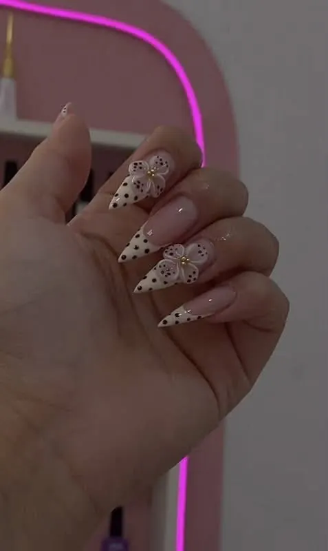 Uñas nude con puntitos negros y flores blancas