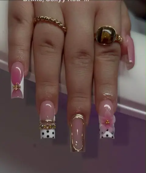 Uñas rosadas con bordes dorados, flores y lunares